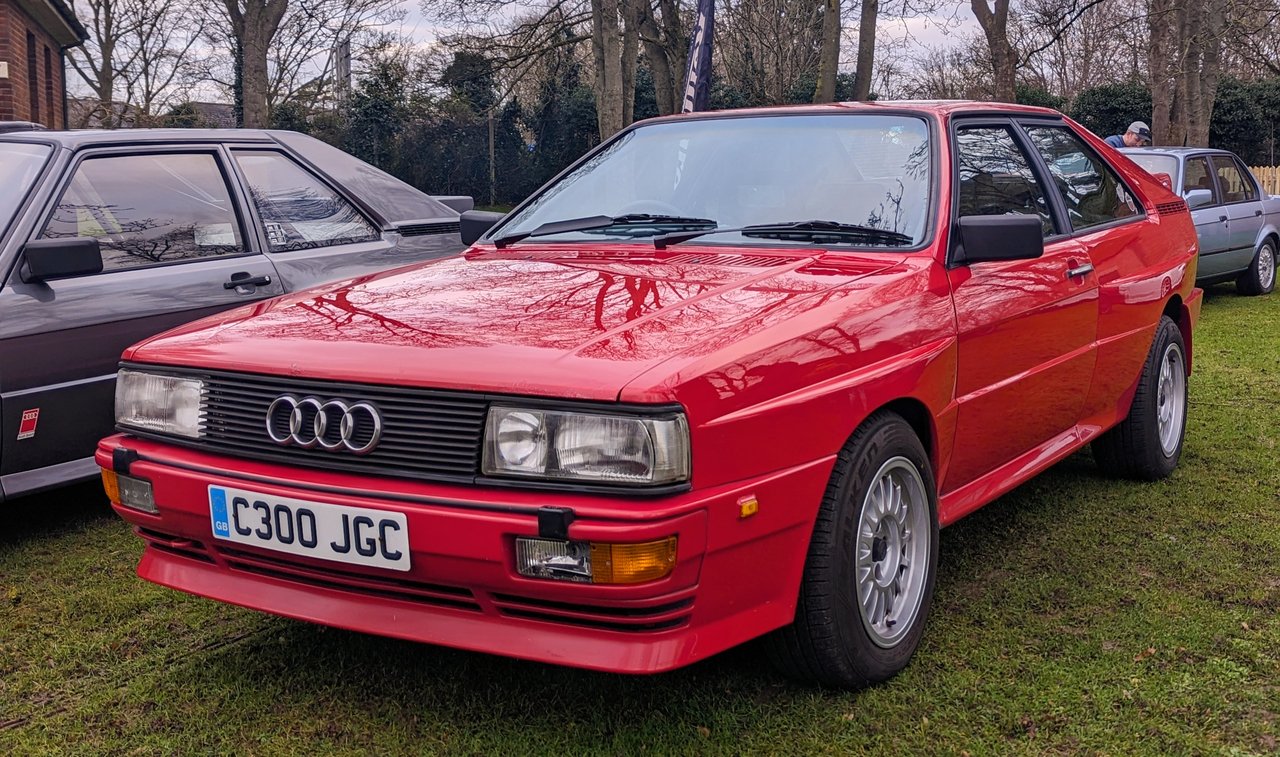 Front three-quarter view of a red Audi quattro coupé with flared wheel arches