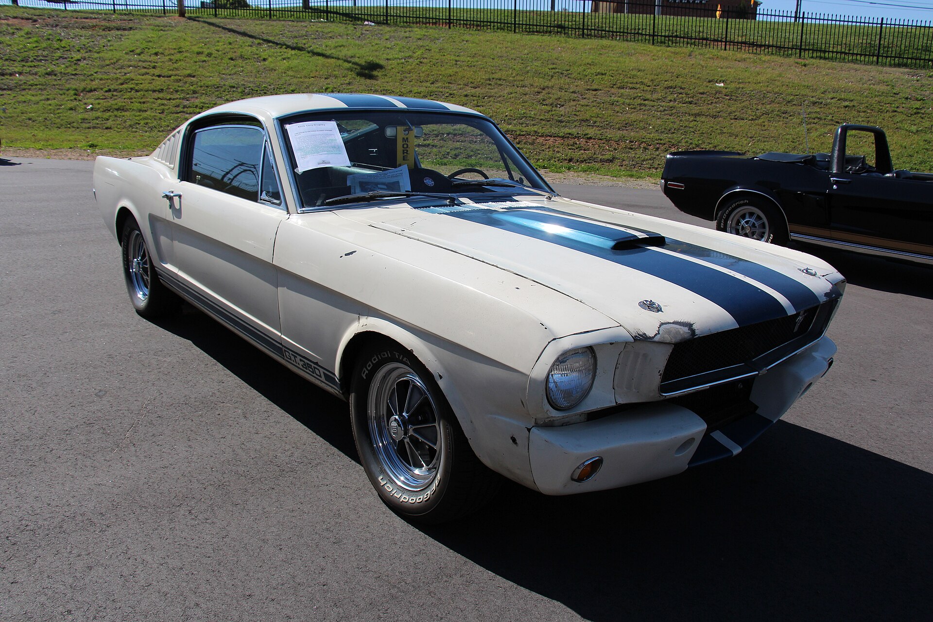 Front three-quarter view of an unrestored white 1965 Shelby GT350 with blue stripes