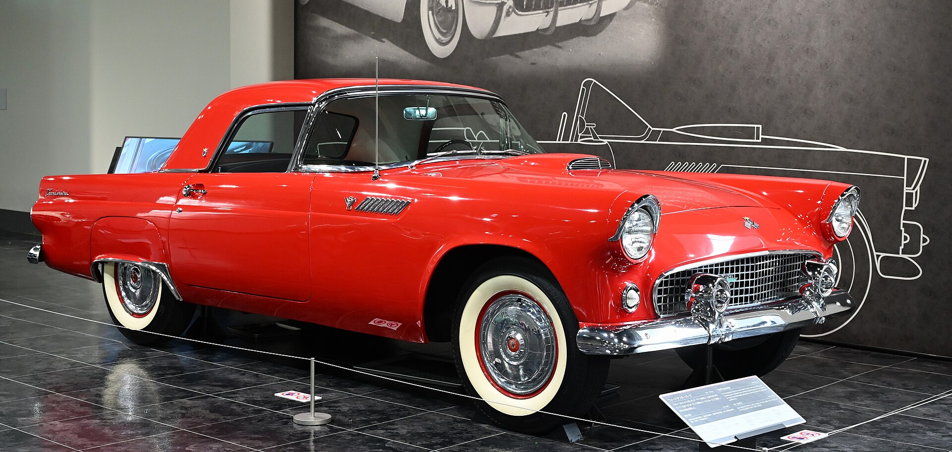 Front three-quarter view of a red 1955 Ford Thunderbird with its removable hardtop fitted
