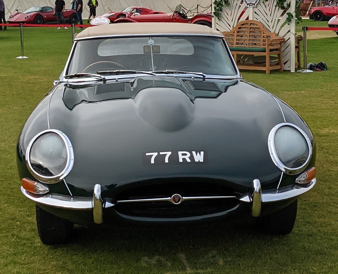 Front view of the dark green Jaguar E-Type roadster 77 RW with its fabric roof raised