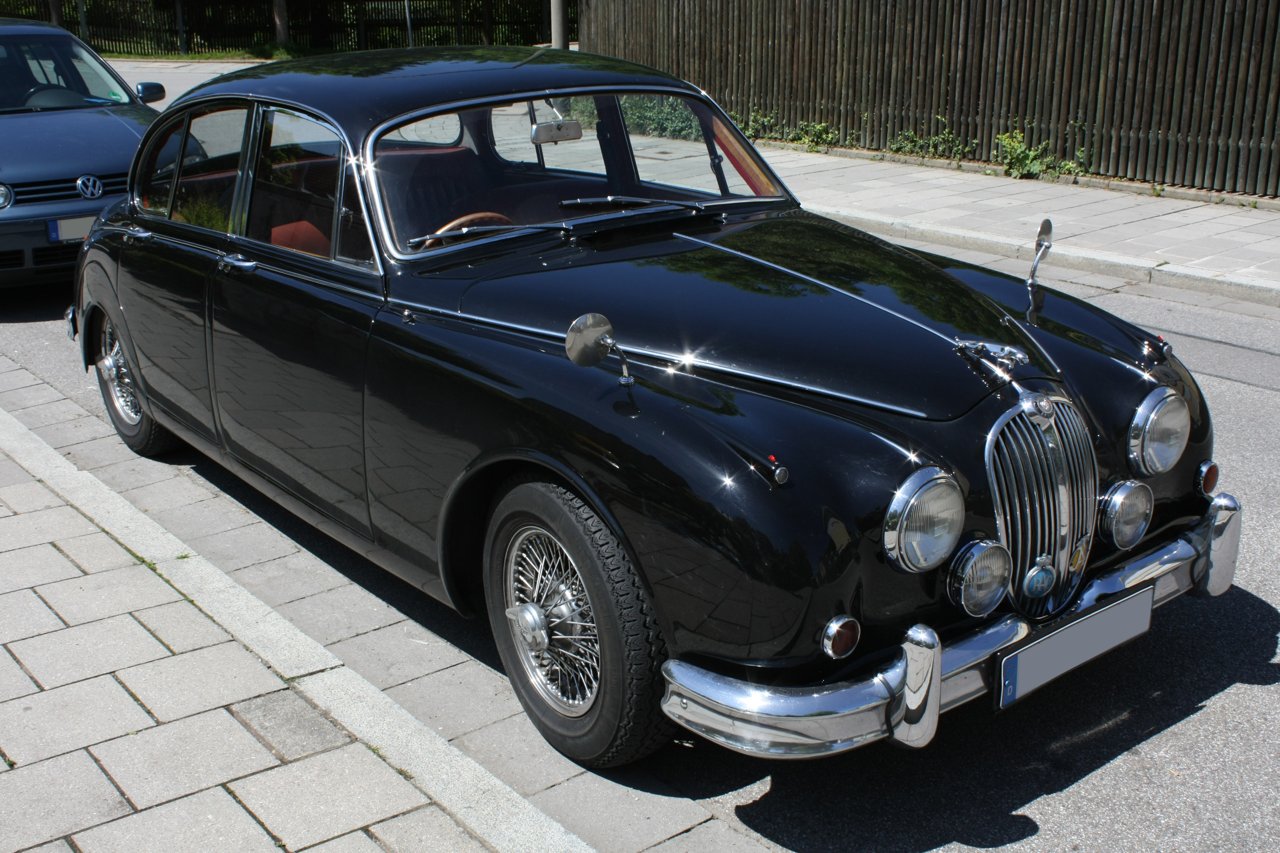 Black Jaguar Mark 2 four-door saloon with wire wheels, viewed from the front and side