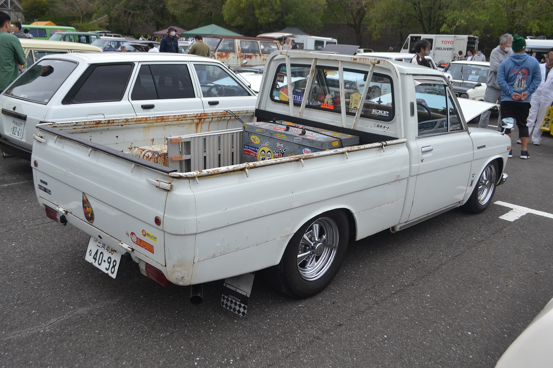 Rear three-quarter view of a white first-generation Toyota Hilux long-body pickup