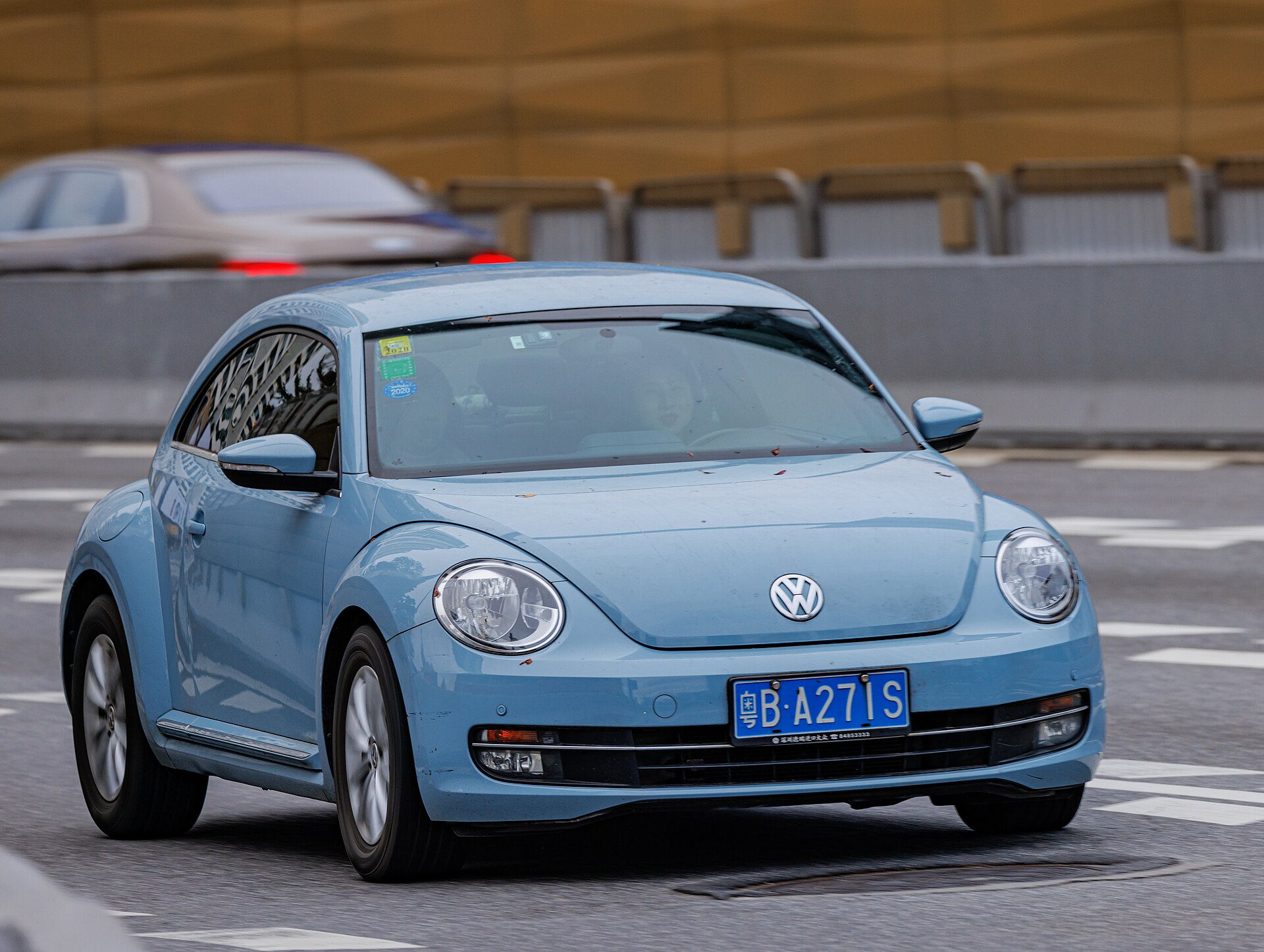 Front three-quarter view of a pale blue Volkswagen Beetle A5 hatchback in motion