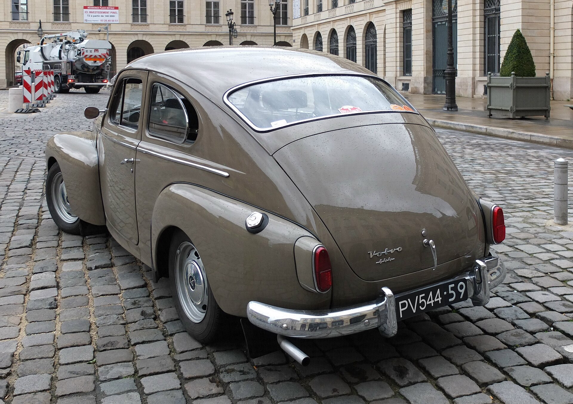 Rear three-quarter view of a grey 1959 Volvo PV544 on a cobbled street